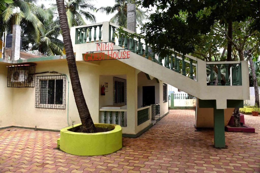 坎多林Niki Guest House的一座有楼梯和棕榈树的建筑
