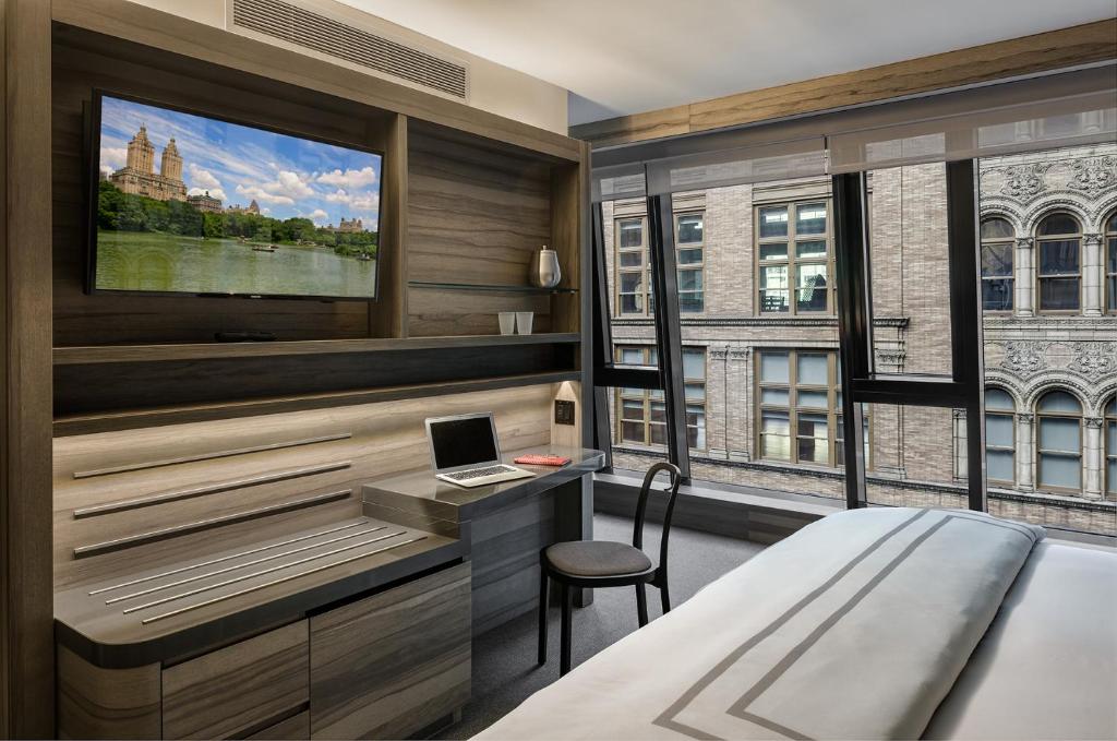 纽约卡内基酒店的一间卧室配有一张床和一张带笔记本电脑的书桌
