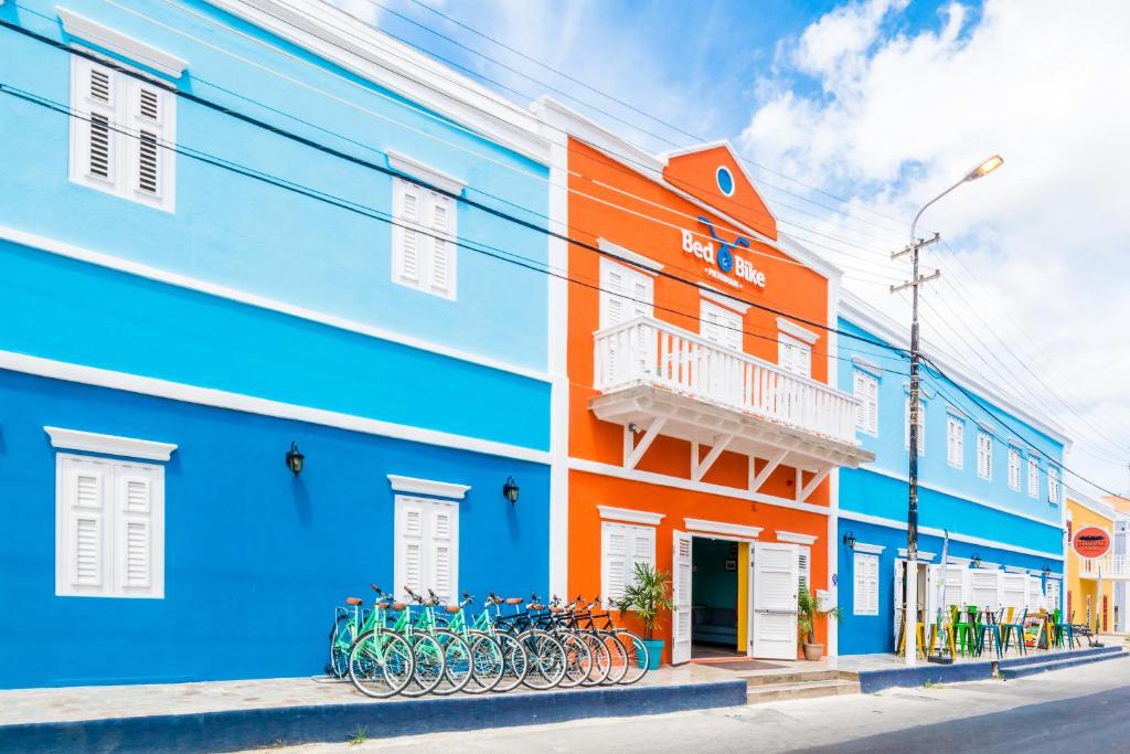 威廉斯塔德Bed & Bike Curacao的一座色彩缤纷的建筑,前面停放着自行车