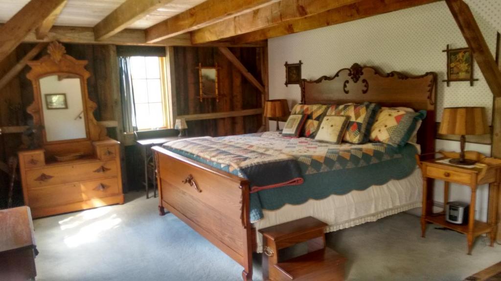 BarreLodge at Millstone Hill的一间卧室配有一张木架床