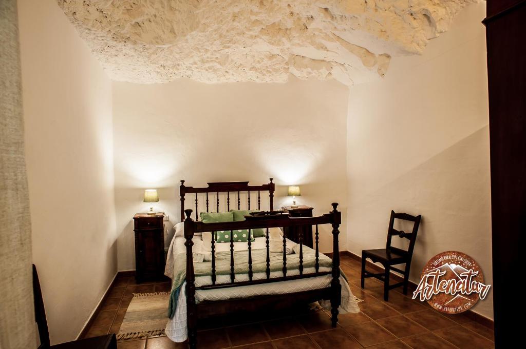 阿尔特纳拉Casa Cueva El Molino的卧室配有1张床、1张桌子和1把椅子