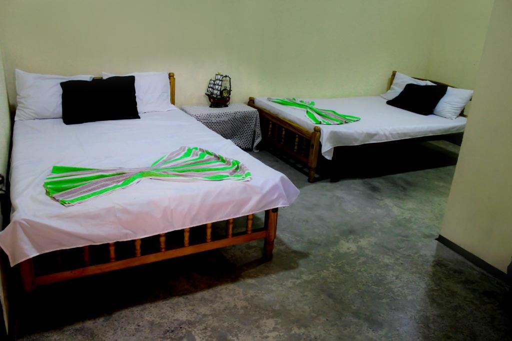 康提康提J旅馆的配有绿丝带的客房内的两张床