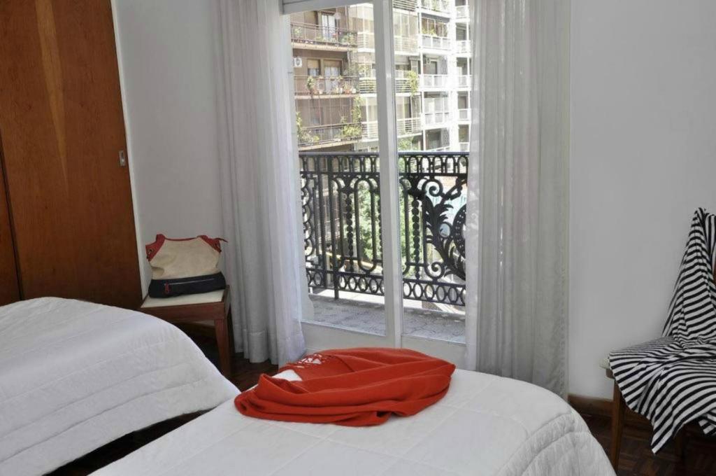布宜诺斯艾利斯佩蒂特雷科莱塔酒店的窗前的一张床上有红毛巾