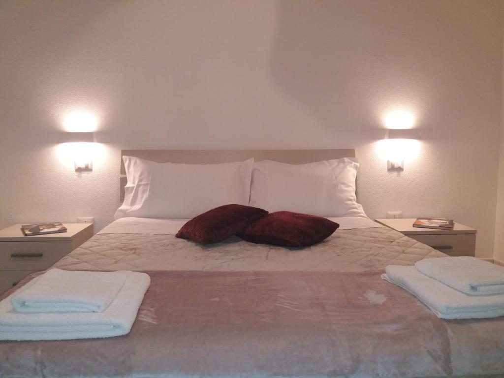 卡利亚里Depandance Machiavelli的一张带两个枕头的床和两条毛巾