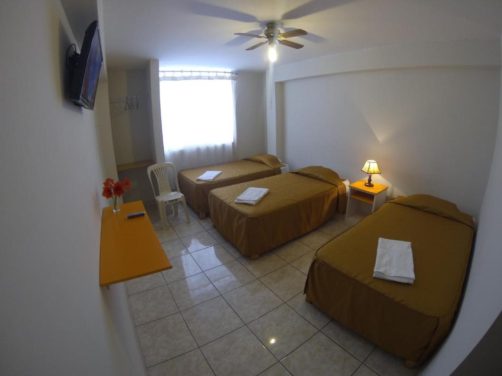 纳斯卡Hospedaje el Telar的酒店客房设有两张床和窗户。