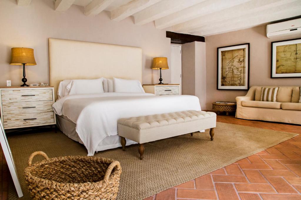 卡塔赫纳卡萨唐桑丘马斯蒂克岛酒店的卧室配有一张白色的大床和一张沙发。