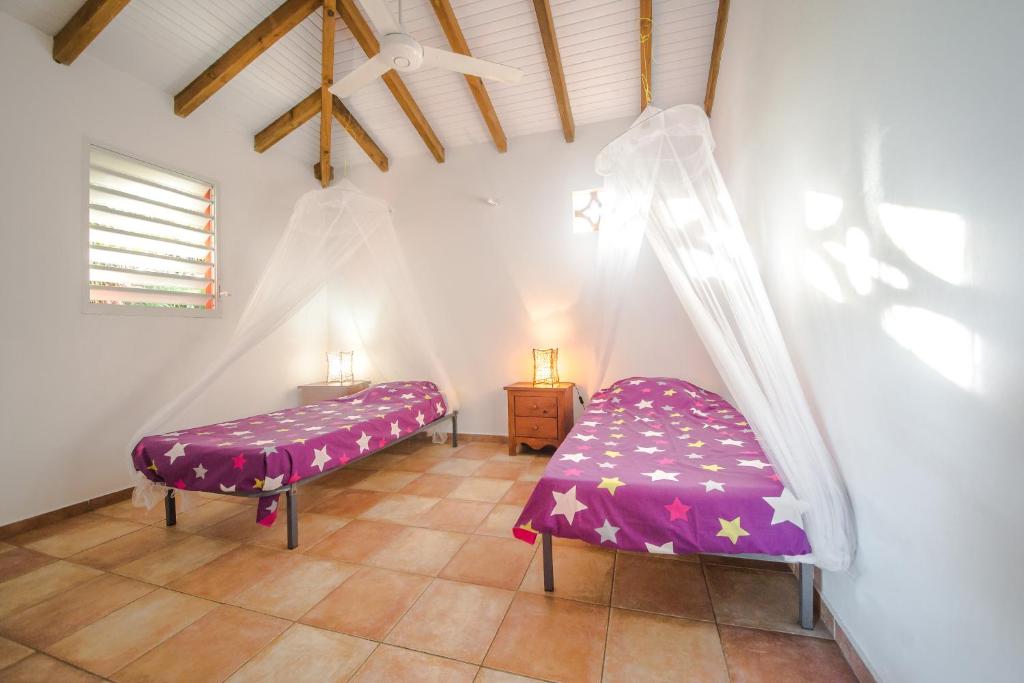 圣弗朗索瓦Sunset Surf Camp的一间设有两张紫色床单的床的客房