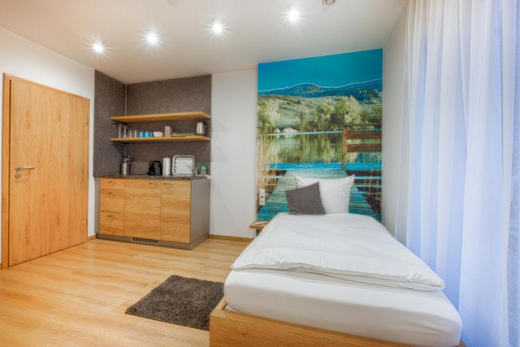 HößlinsülzPension Breitenauer See的卧室配有一张床,墙上挂有绘画作品