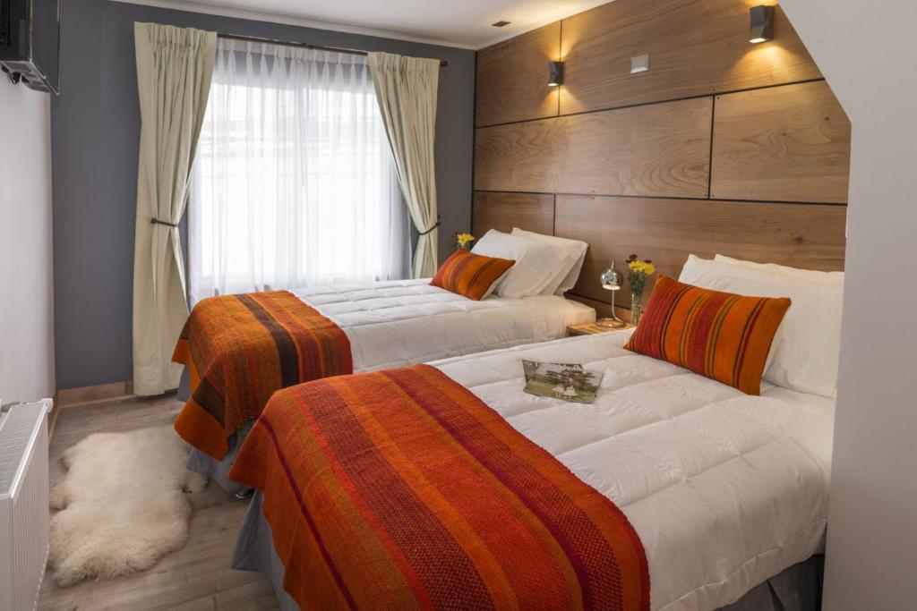 蒙特港Hotel Angelmontt的酒店客房设有两张床和窗户。