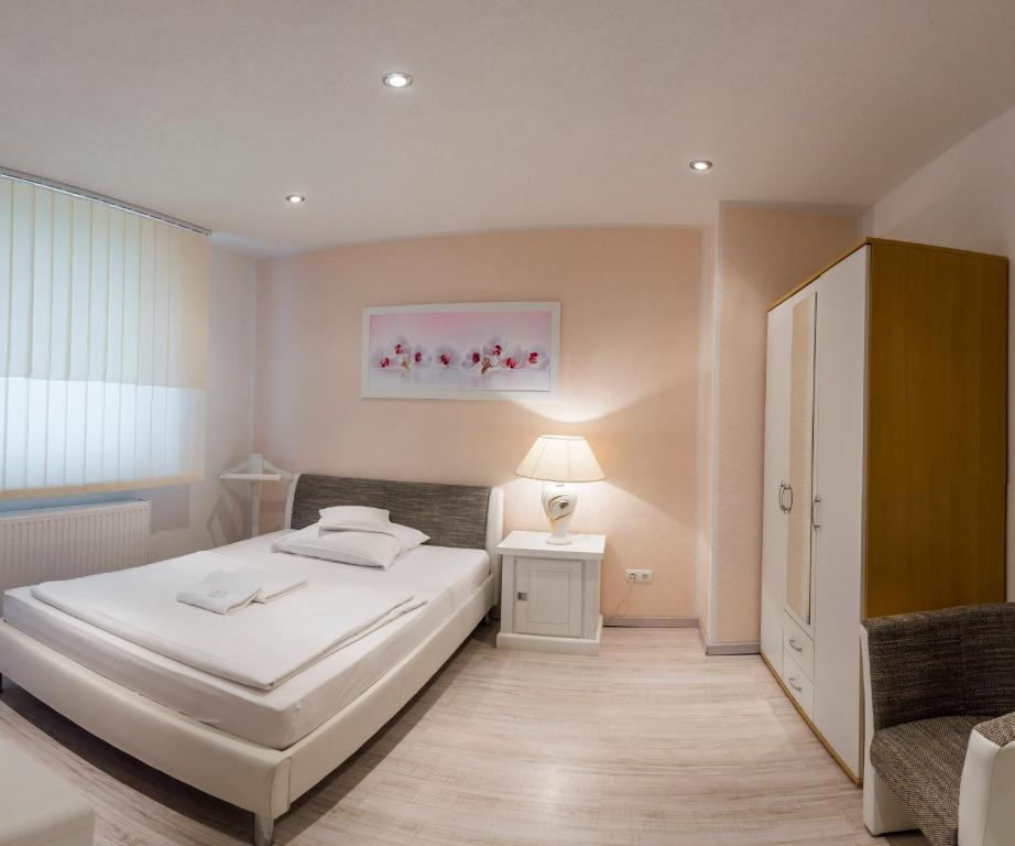 汉诺威多瑙河旅馆的卧室配有白色的床和椅子