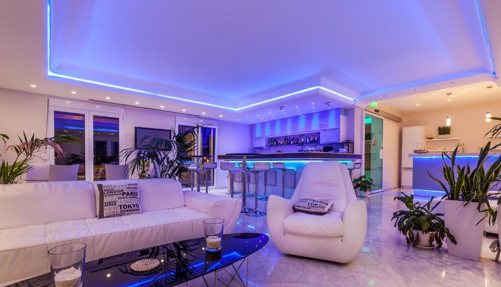 弗隆塔多斯珍珠湾公寓式酒店的一间带2张白色沙发的客厅和一间酒吧