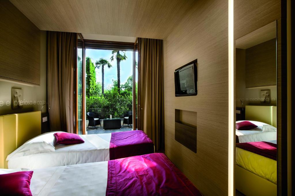 罗马Hotel Il Cantico St. Peter的酒店客房设有两张床和窗户。