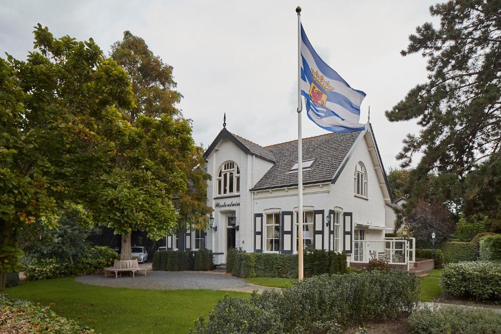 雷讷瑟维斯特尔杜因住宿加早餐旅馆的白色房子前面悬挂的旗帜