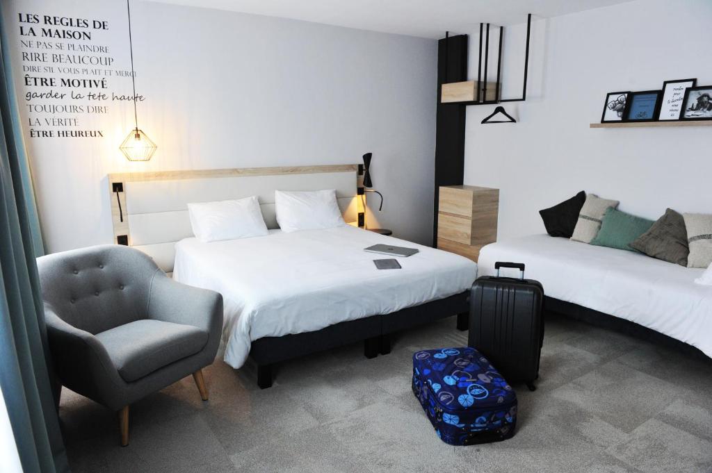 瓦讷Urban Style Hotel de France的一间卧室配有两张床、椅子和行李箱