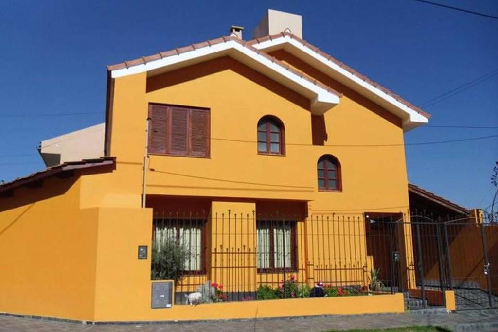 萨尔塔Casa en B° Tres Cerritos, Salta Capital. Alquiler Temporal的前面有栅栏的黄色房子