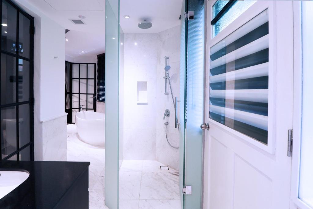 新加坡Hotel NuVe Urbane的带淋浴、盥洗盆和卫生间的浴室