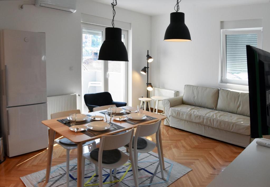 乌日策非凡公寓的客厅配有桌子和沙发