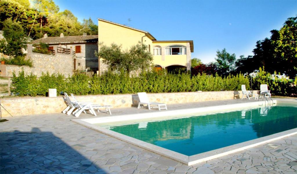 VigneBelvedere Cramaccioli的一个带椅子的游泳池和一个背景房子