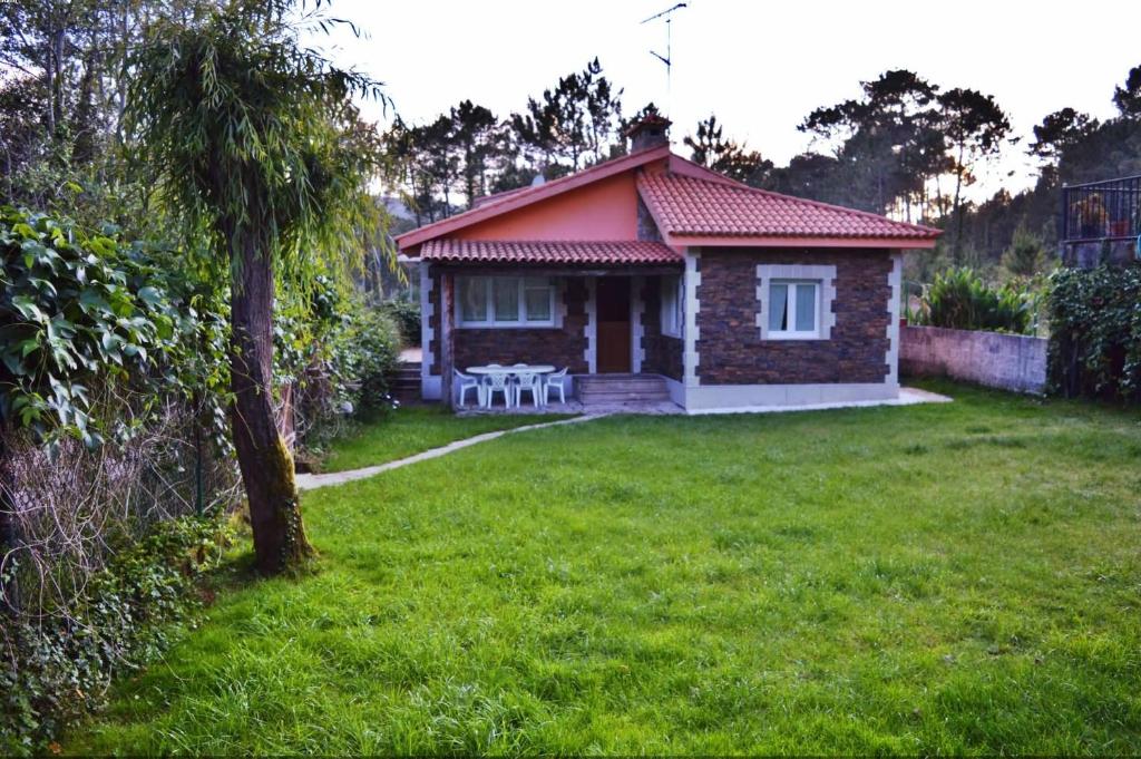 菲尼斯特雷Casa Playa Fisterra的院子中一座红色屋顶的小房子
