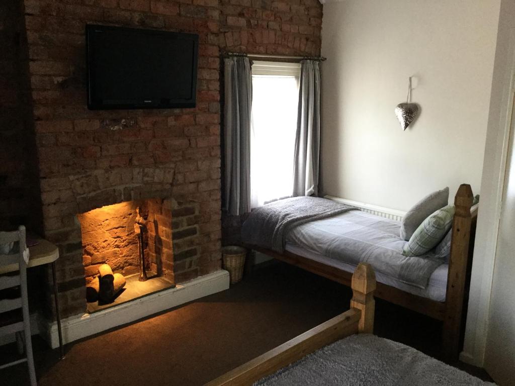 奇德尔亨斯曼酒店的一间卧室设有壁炉、电视和窗户