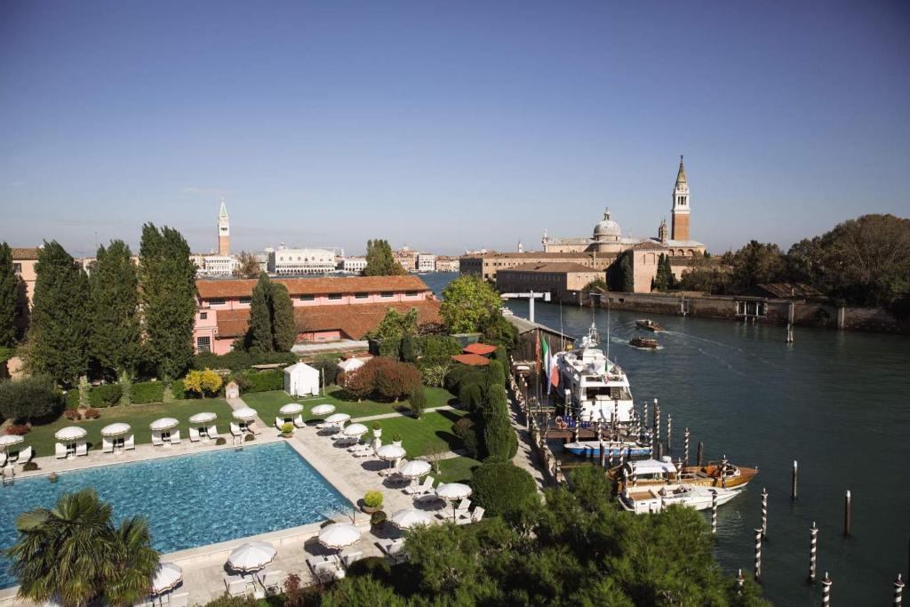 威尼斯Hotel Cipriani, A Belmond Hotel, Venice的河边的大型游泳池,有船