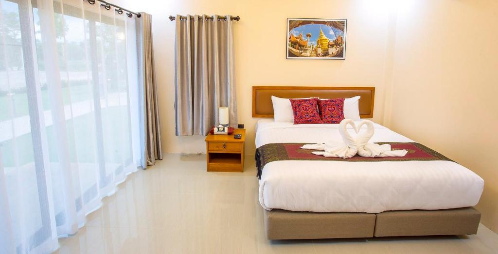 Ban Chomphu南邦绿色花园度假村的一间卧室配有一张带白色天使的床