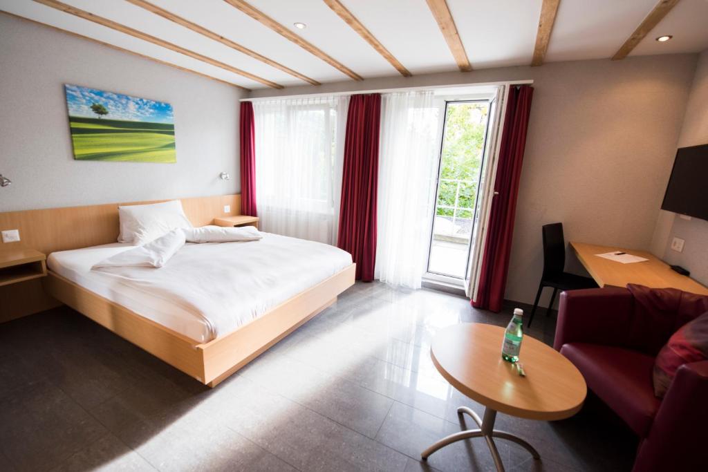 Hertenstein诺伊豪斯餐厅酒店的一间卧室配有一张床、一张桌子和一张沙发
