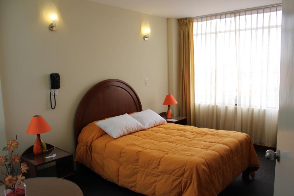 阿雷基帕阿尔莫哈达德尔雷酒店的一间卧室配有一张带橙色毯子和窗户的床。