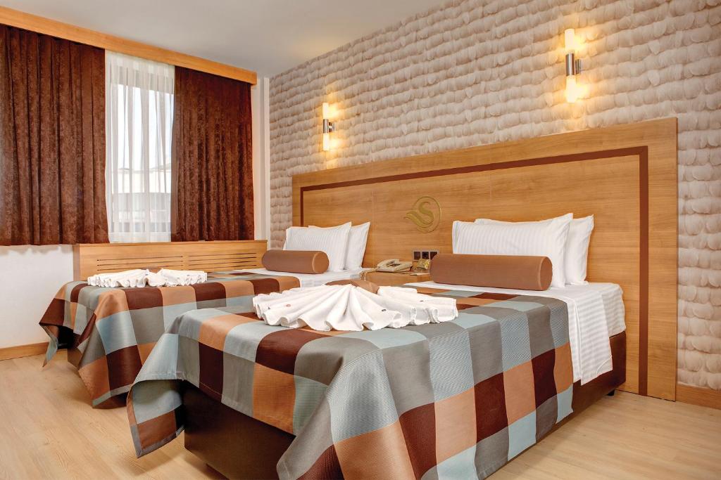 伊兹密尔苏苏祖鲁赛金酒店的一间酒店客房,房间内设有两张床