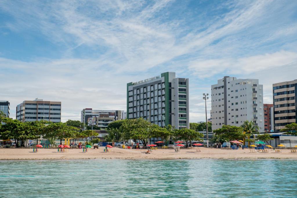 马塞约Hotel Sete Coqueiros的城市里一片带人和遮阳伞的海滩