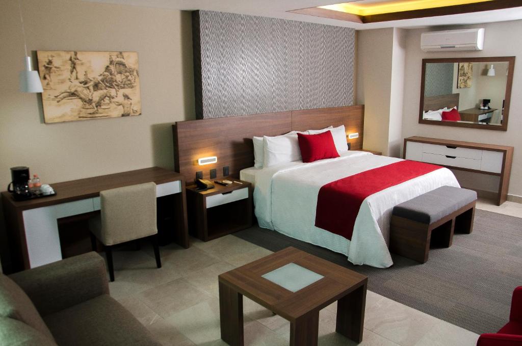 普埃布拉Hotel 5 de Mayo的酒店客房设有一张大床和一张书桌。