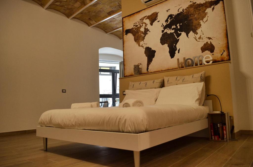 塔尔奎尼亚B&B Chiostro San Marco的一间卧室配有一张大床,墙上挂着世界地图