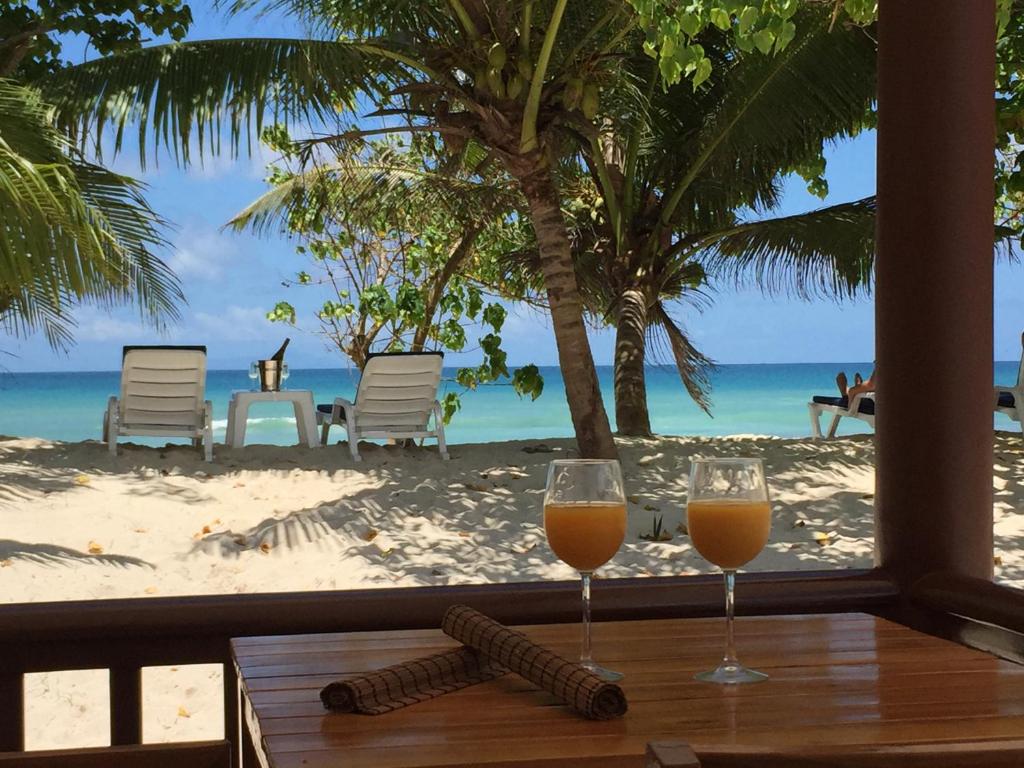 Anse Kerlan贝勒普拉格别墅的海滩前桌子上放两杯橙汁
