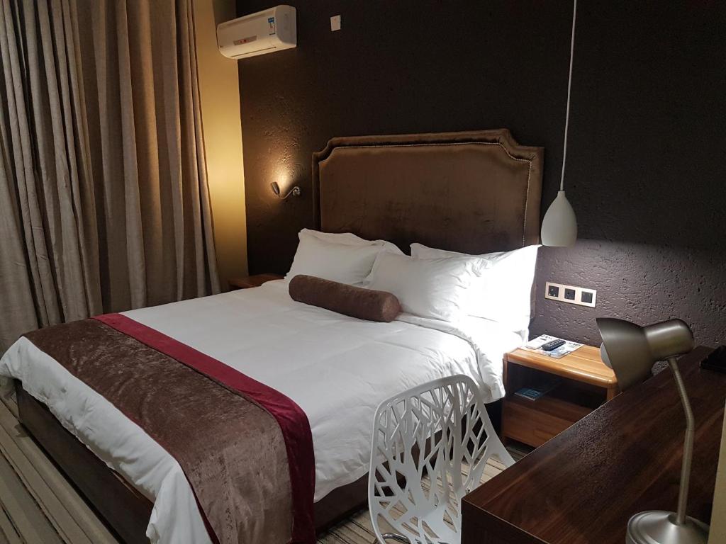 弗朗西斯敦La Signature Guest house的酒店客房配有一张床和一张带台灯的书桌