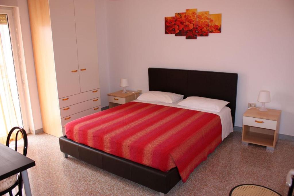 马泰拉维拉住宿加早餐旅馆的一间卧室配有一张带红色条纹毯子的床