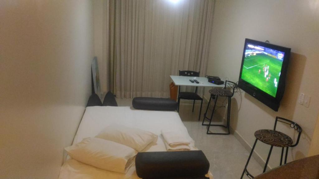 维多利亚Apart Hotel Quartier Latin的小房间设有一张床和一台电视机