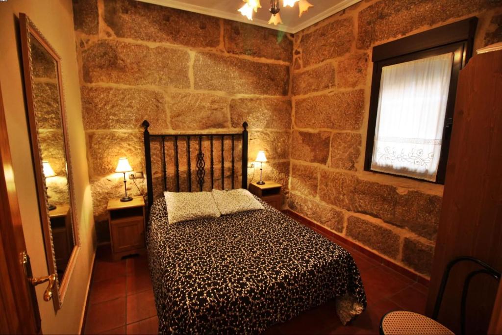 格罗韦Casa Balbina的卧室配有一张石墙床