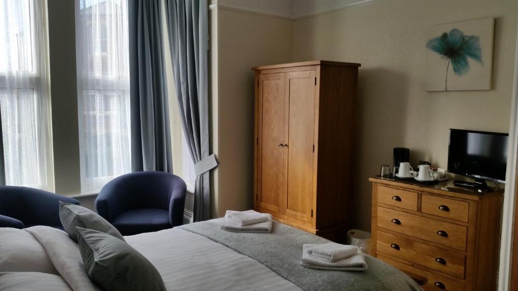 布里德灵顿坦尼森酒店的一间卧室配有一张床、梳妆台和电视。