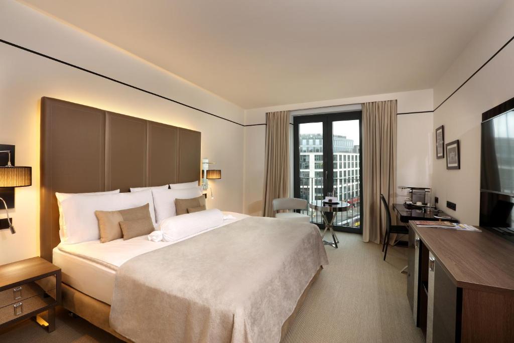 柏林柏林美利亚酒店的酒店客房设有一张大床和一张书桌。