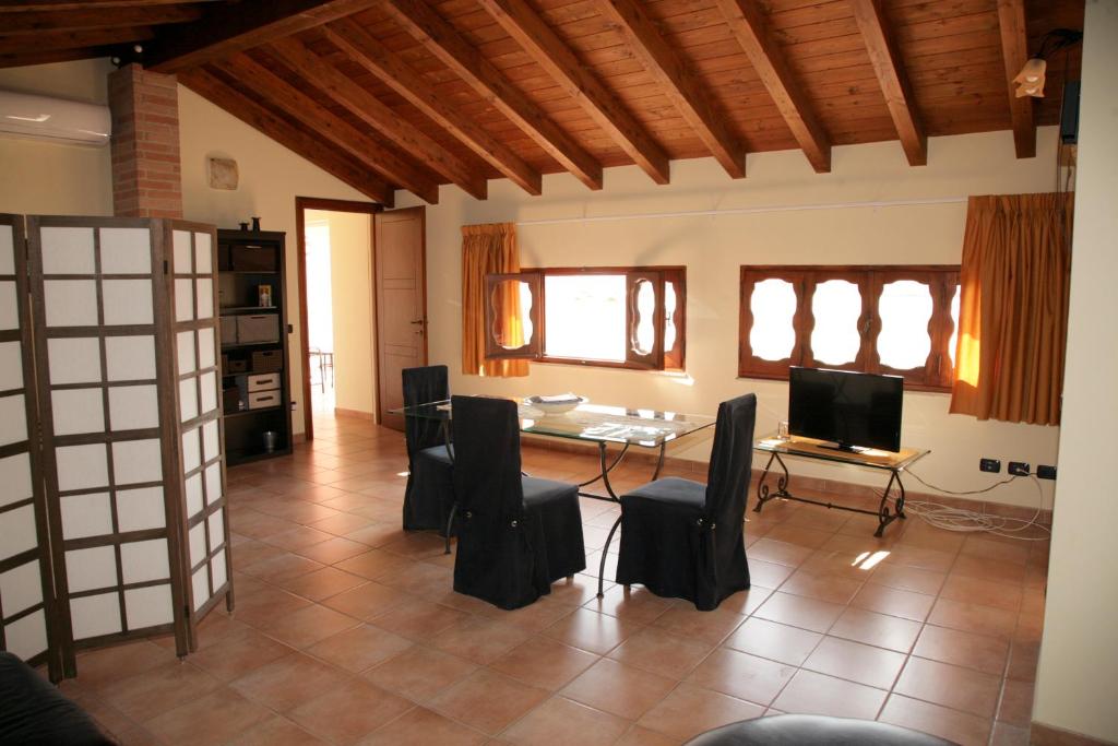 蒙塞拉托L'Isola Felice Apartment的客厅配有桌椅和电视。