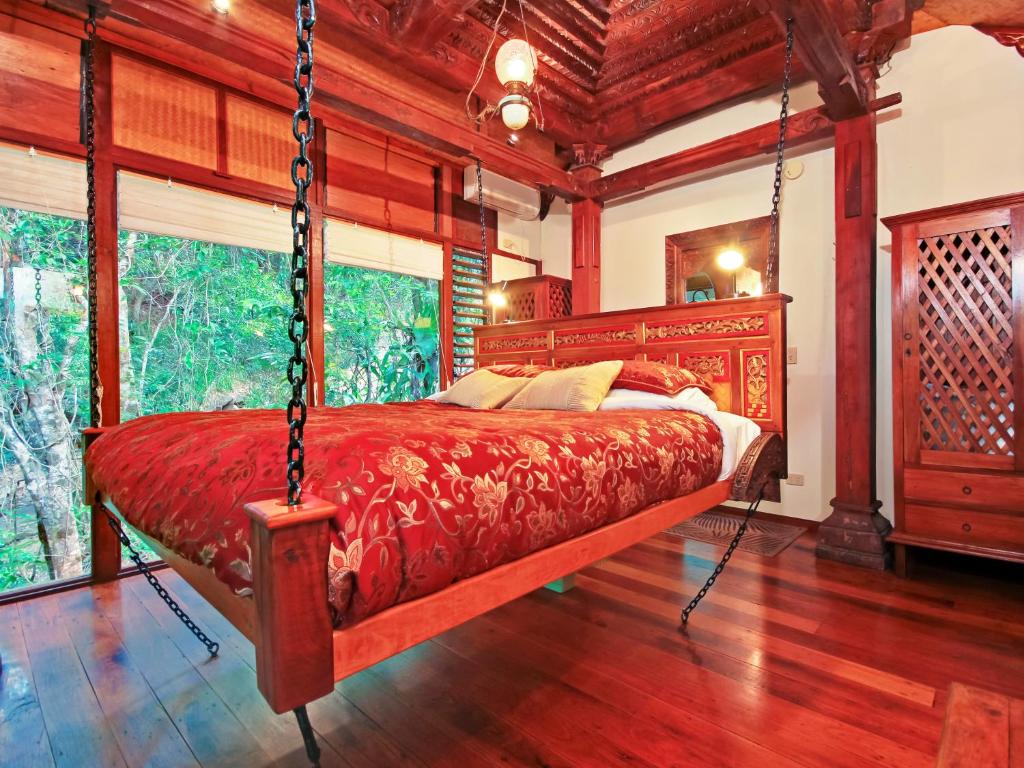 UkiWollumbin Palms Rainforest Retreat的卧室配有秋千床。