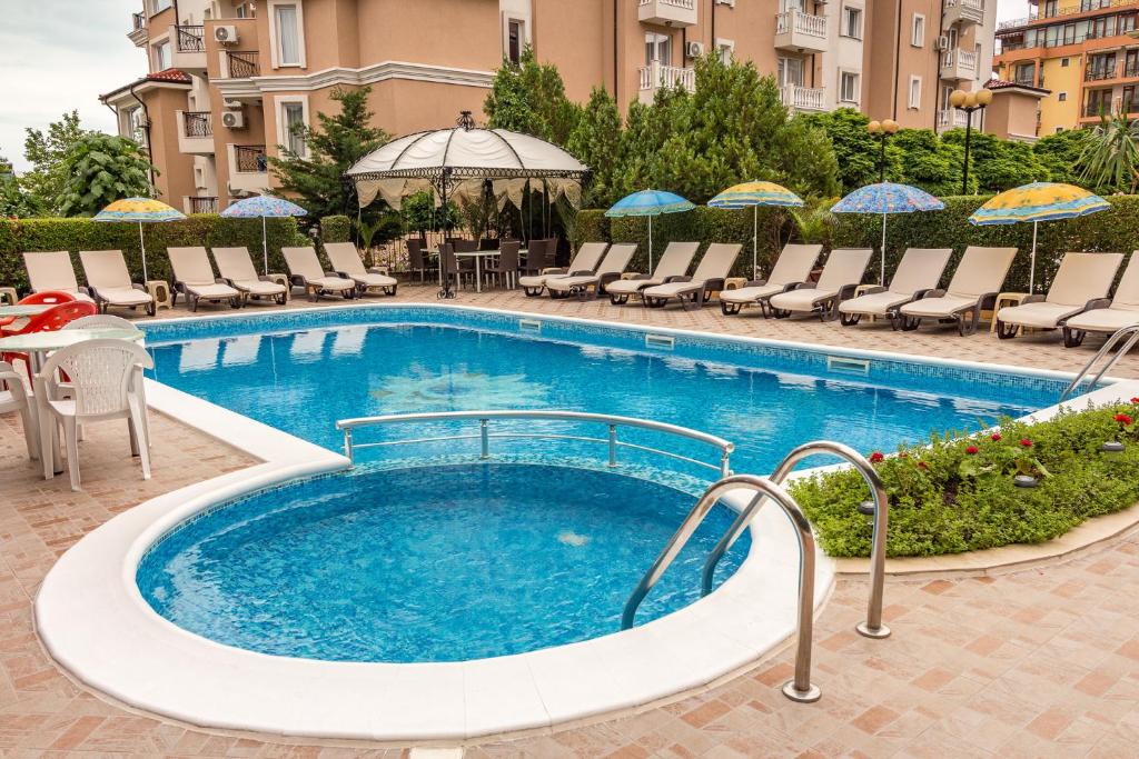 圣弗拉斯家庭金星大酒店的一个带椅子和遮阳伞的大型游泳池