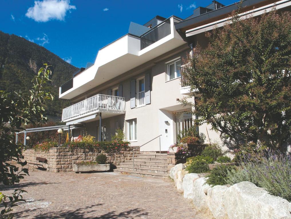 拉纳Ausserdorfer Apartments的一座位于山上的白色建筑,设有阳台