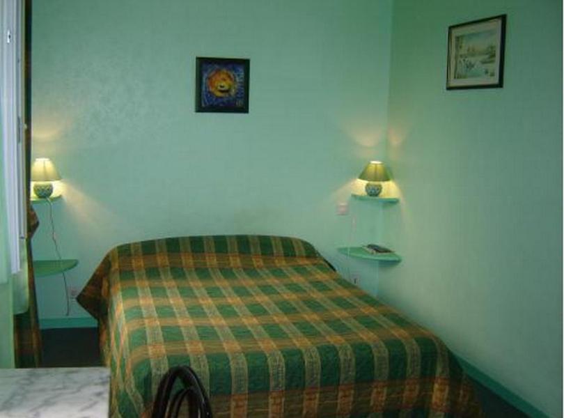 希农堡里奥多赫酒店及餐厅的卧室配有一张床,墙上配有两盏灯。