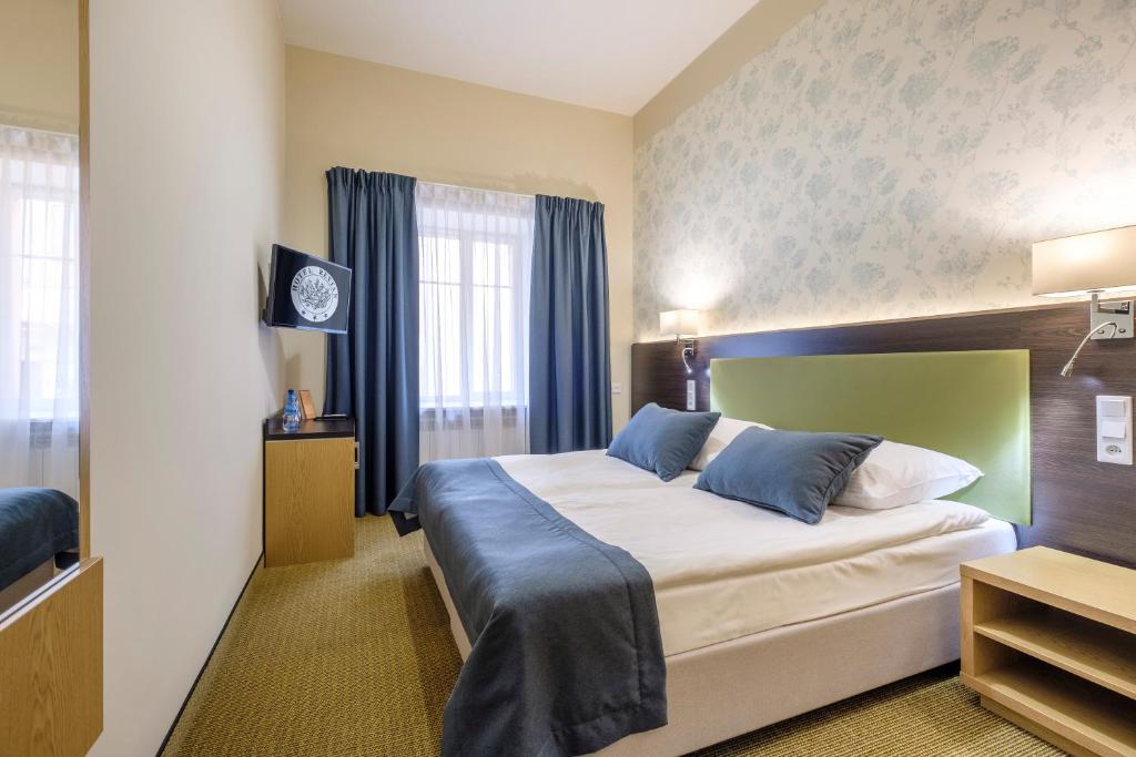 华沙雷坦酒店的酒店客房配有一张带蓝色枕头的大床