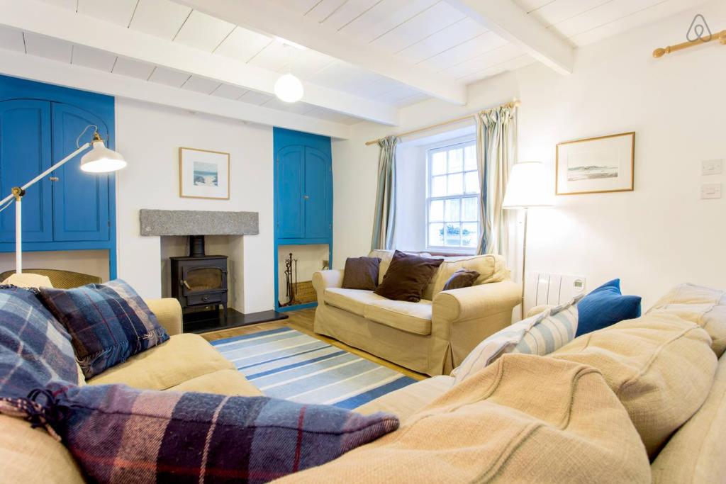 圣莫斯Fisherman's Cottage的客厅设有两张沙发和一个壁炉