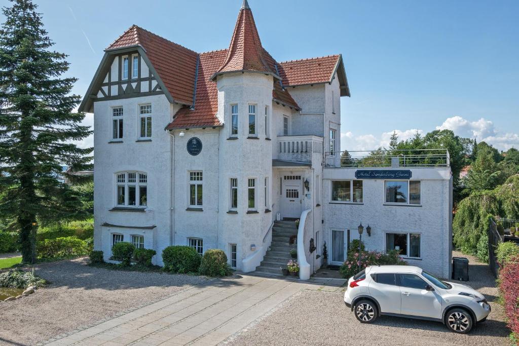 森讷堡桑德堡嘉妮酒店的停在大房子前面的汽车