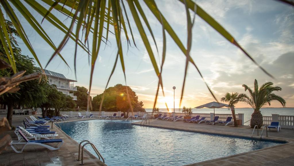 圣卡洛斯拉腊皮塔卡洛斯三世酒店的一个带躺椅的游泳池和海洋
