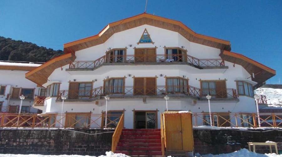 乔斯希马特Ski & Snow Cliff Top Club Holiday Resort at Auli, Uttarakhand的一座白色的大建筑,地面上积雪