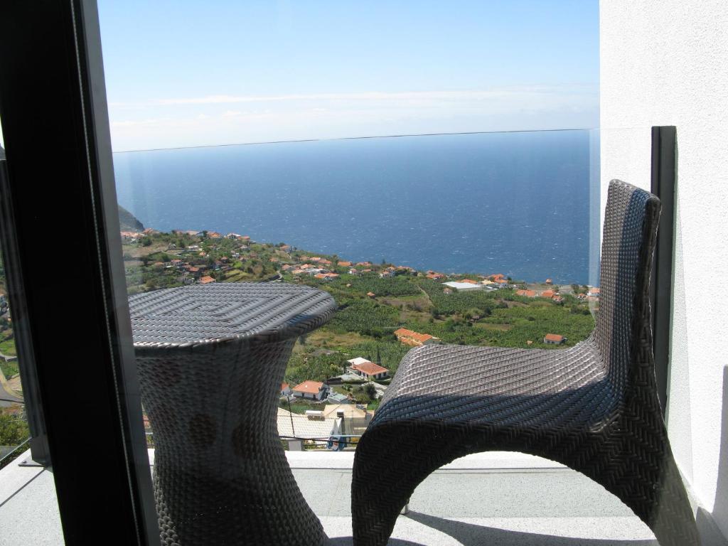 阿科达卡列塔Villa Girasol的椅子坐在阳台,眺望着大海
